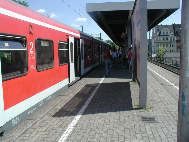 Treno regionale rosso in stazione con viaggiatori