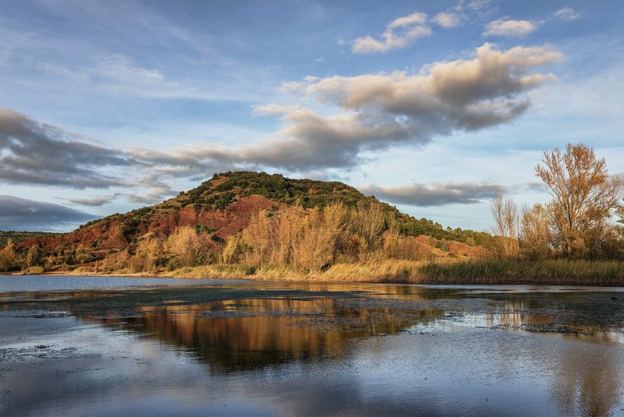 Der Lac du Salagou mit roter Uferlandschaft im Hérault