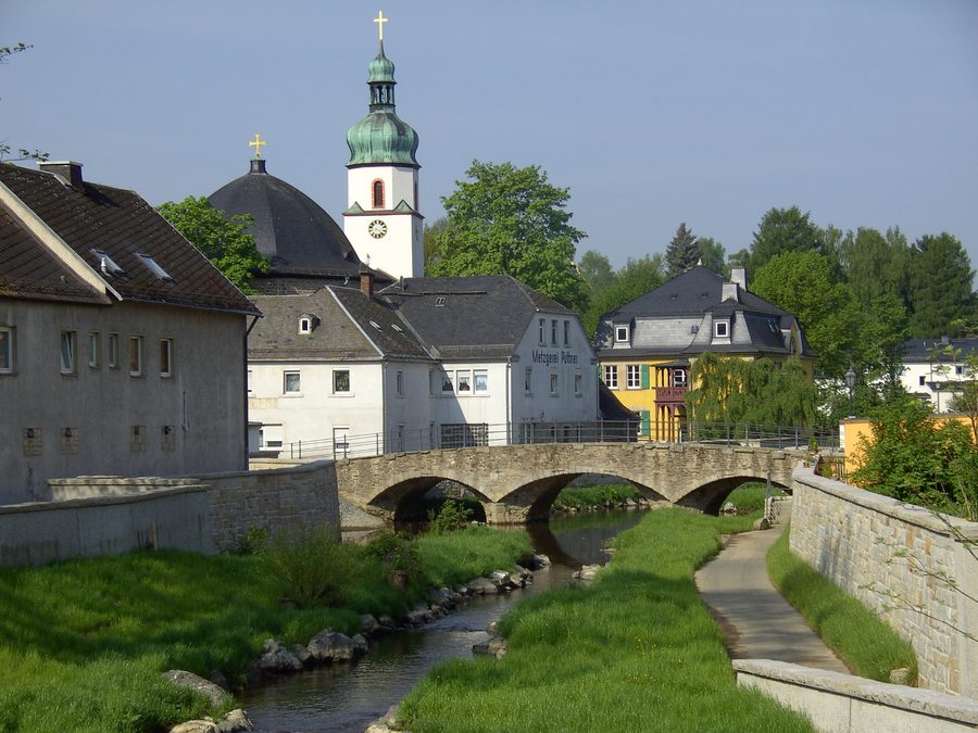 Brücke über die Schwesnitz in Oberkotzau mit der evangelischen Kirche St. Jakobus im Hintergrund.