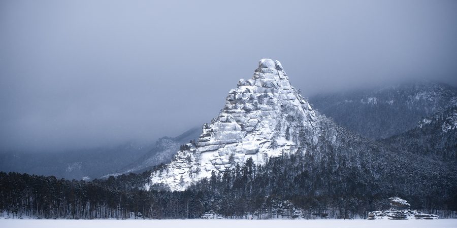 Felsiger Granitfelsen über dem Wald im Burabay-Nationalpark im Winter
