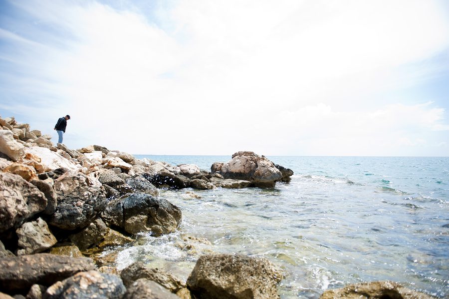 Un visitatore cammina tra le rocce lungo la costa del Mediterraneo nella provincia di Mersin, Turchia