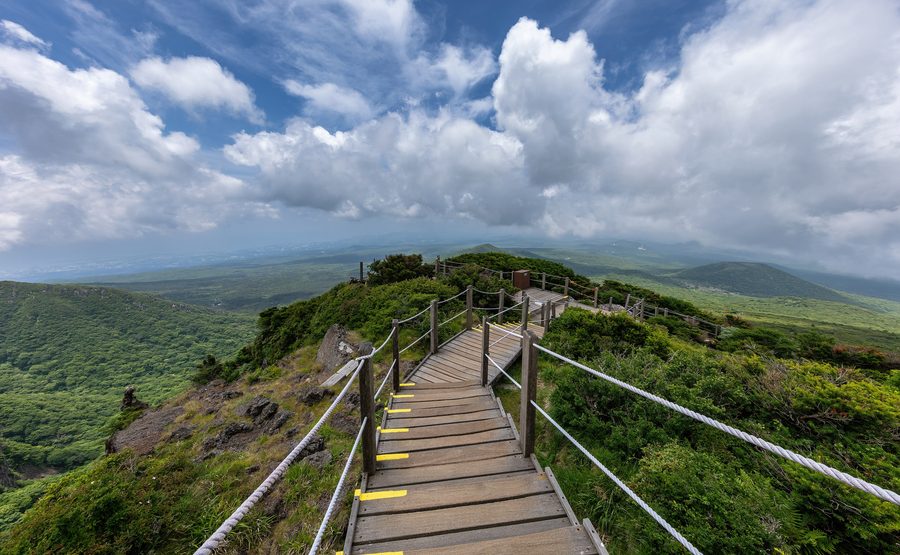 Scala in legno lungo il sentiero Yeongsil con le montagne del Hallasan a Jeju
