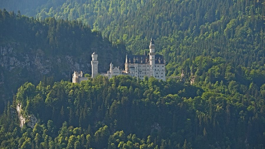 Castello di Neuschwanstein presso Schwangau davanti al paesaggio montano bavarese