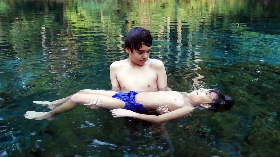 Due persone nuotano in un fiume tranquillo, circondato da una vegetazione fitta, a Las Estacas presso Tlaltizapán.