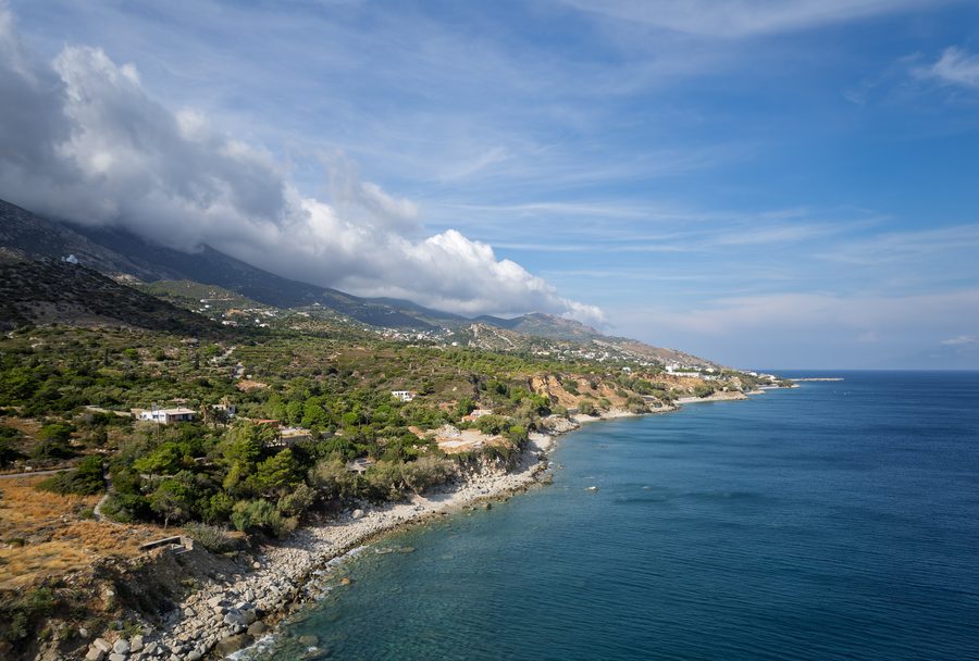 Vista aerea della costa meridionale montuosa di Ikaria con Agios Kirykos in lontananza