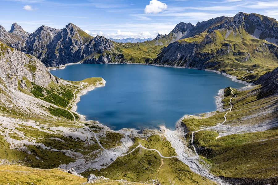 Luftaufnahme des Lünersees in Vorarlberg mit Staumauer, Seilbahnstation und Alpen im Hintergrund