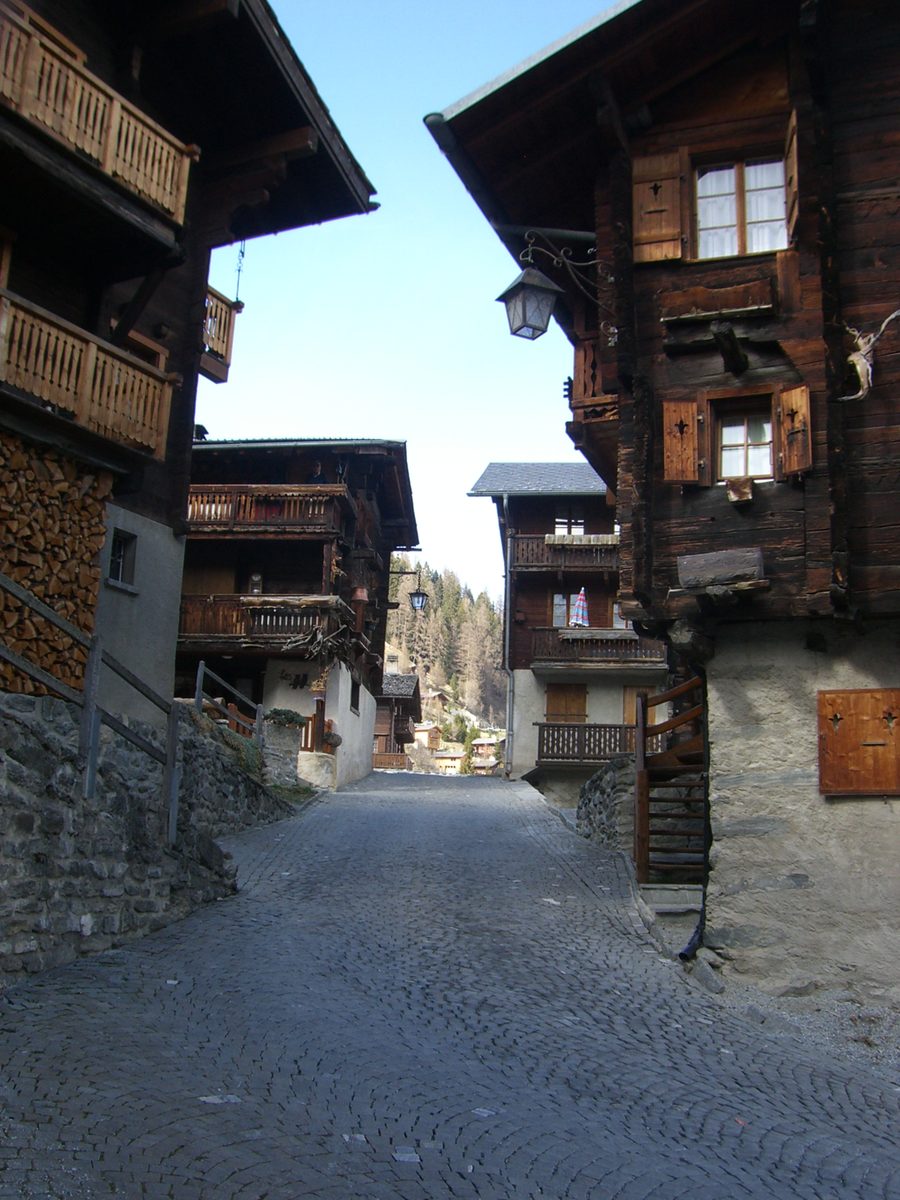 Enge historische Gasse mit traditionellen Holzhäusern in Grimentz im Wallis