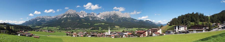 Villaggio alpino di Ellmau con pendii verdi e una vasta valle in estate.