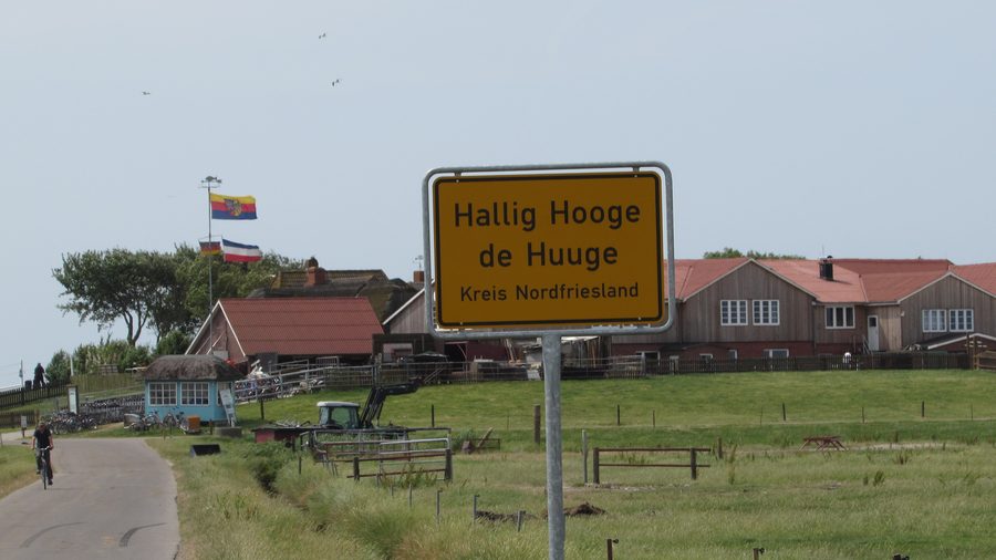 Cartello bilingue della località Hallig Hooge davanti alla Backenswarft