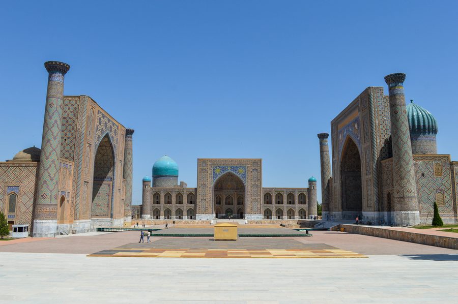 Das Registan-Ensemble in Samarkand mit drei reich verzierten Medresen unter blauem Himmel.
