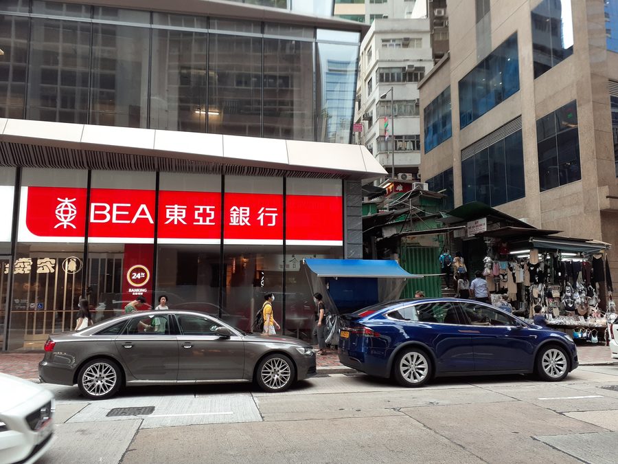 Scena stradale su Queen's Road Central a Hong Kong con una filiale della Bank of East Asia.