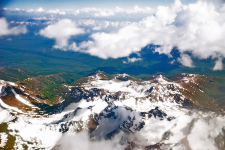 Blick aus einem Flugzeug auf die schroffen, schneebedeckten Gipfel des Pamir in Tadschikistan.