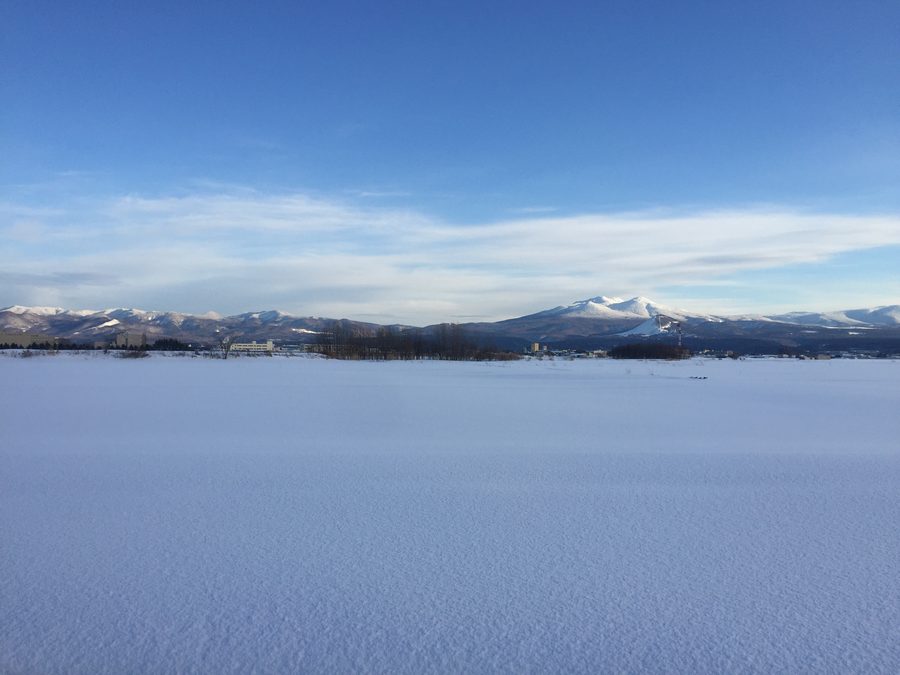 The Hakkōda Mountains rising beyond snowy paddy fields south of central Aomori
