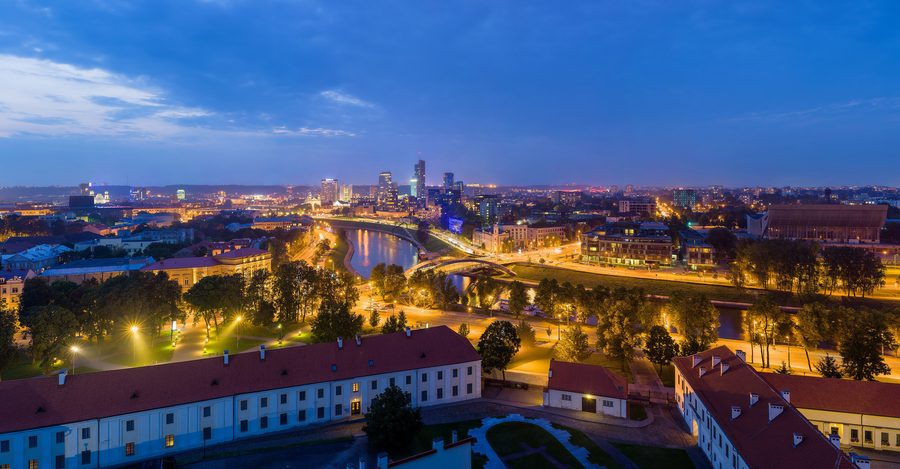 Skyline di Vilnius al crepuscolo con edifici illuminati.