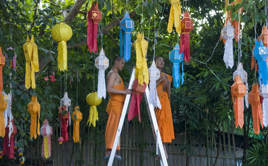 Buddhist monks installing lanterns in Chiang Mai, Thailand.