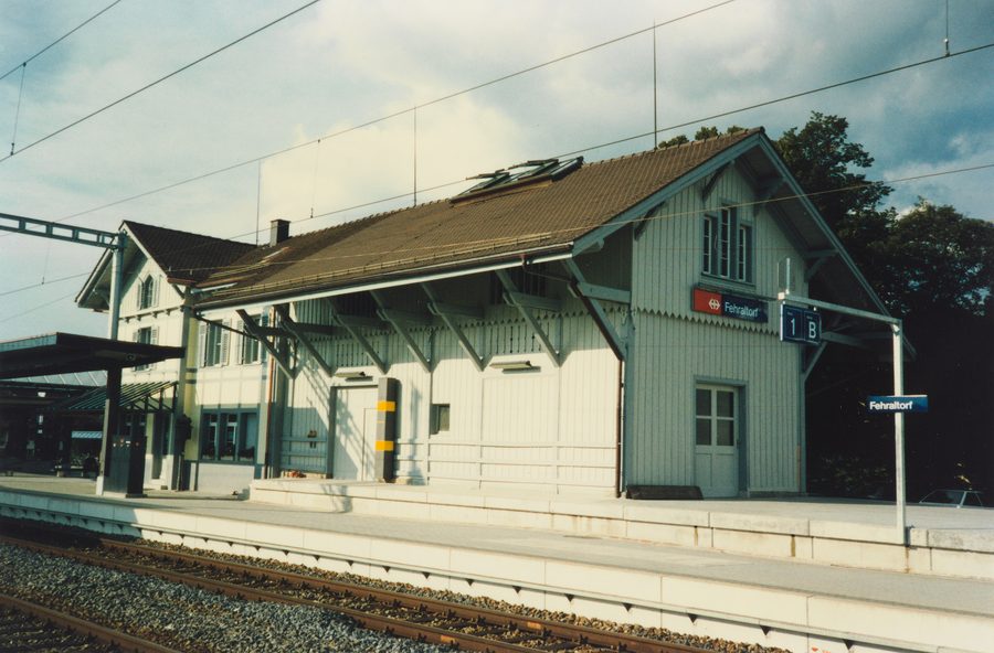 Historisches Bahnhofsgebäude von Fehraltorf mit Güterschuppen auf der Bahnseite