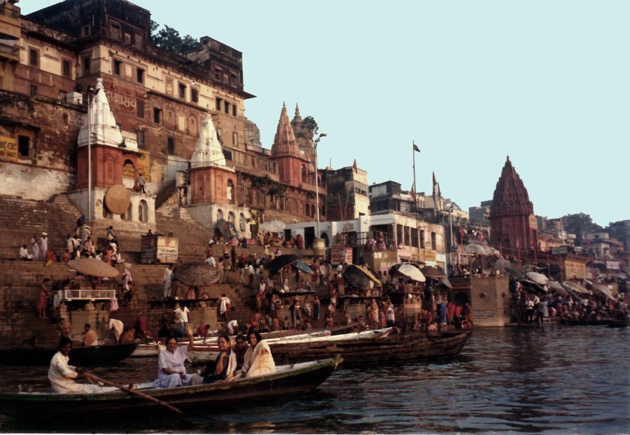 Il Gange all’alba accanto ai ghat di Varanasi, con barche sul fiume.