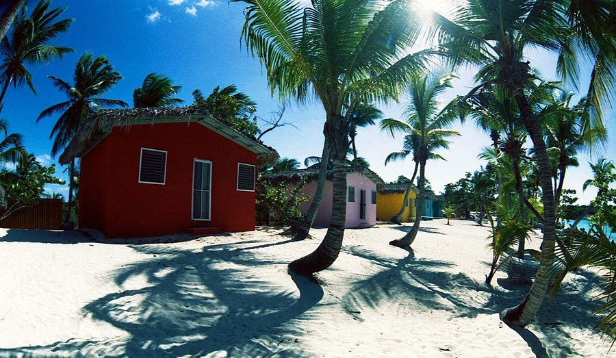 Spiaggia tropicale caraibica con acqua blu calma e case sulla spiaggia a Isla Catalina.