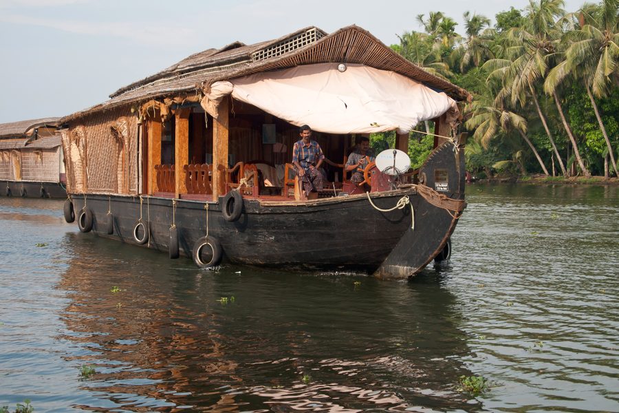 Houseboats on calm water in the Kerala backwaters.