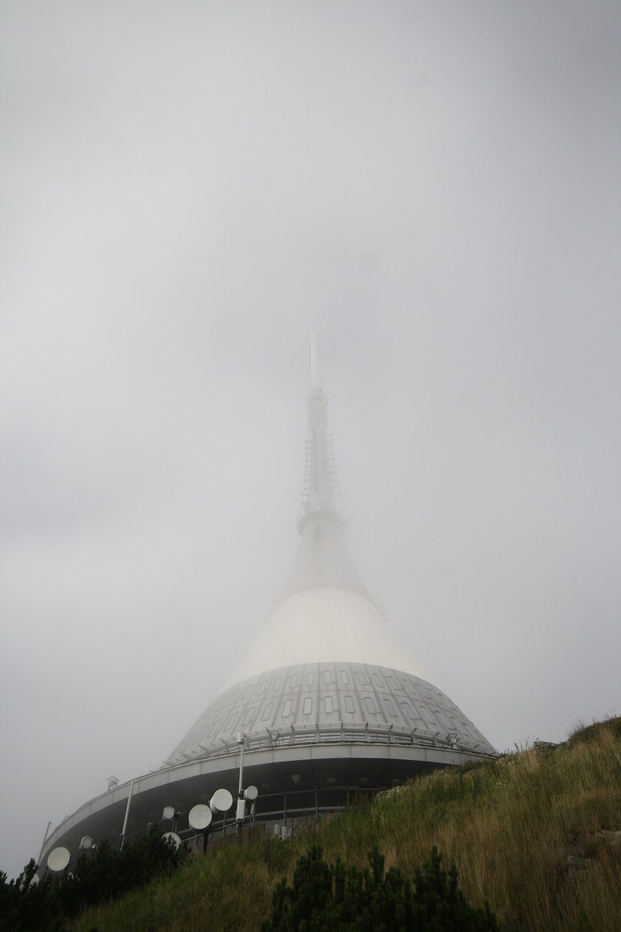 Ještěd tower rising above Liberec in fog.