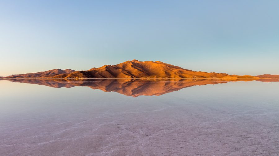 Salt flat panorama of the Salar de Uyuni with mountains in the distance.