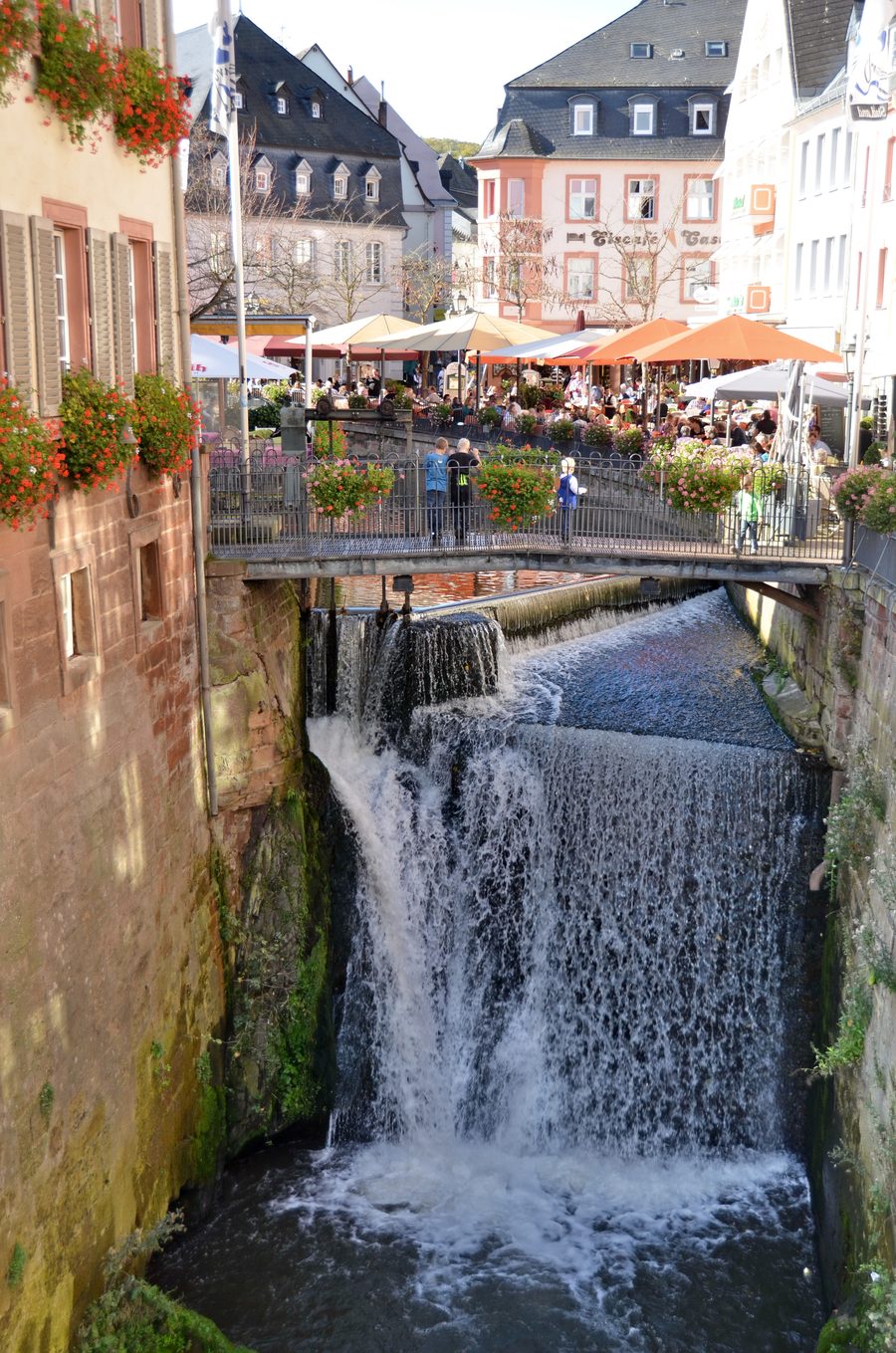 Famous waterfall in Saarburg with visitors on a sunny autumn day